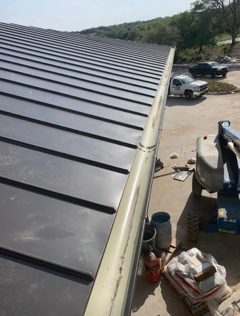 Standing seam panel and gutter detail on a metal roofing jobsite in Berwick